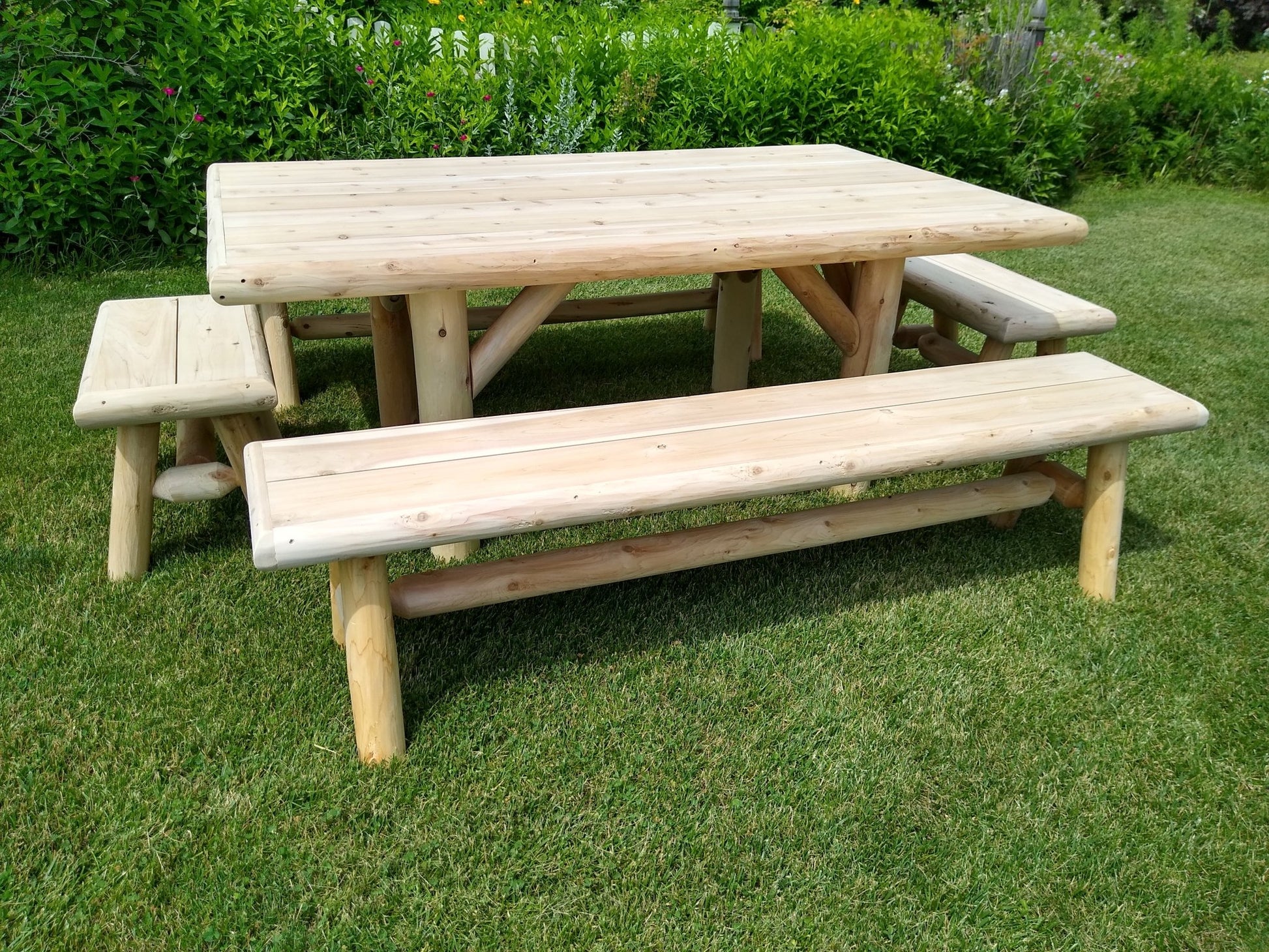 Rustic picnic tables featuring sturdy log construction, ideal for outdoor seating and picnics.