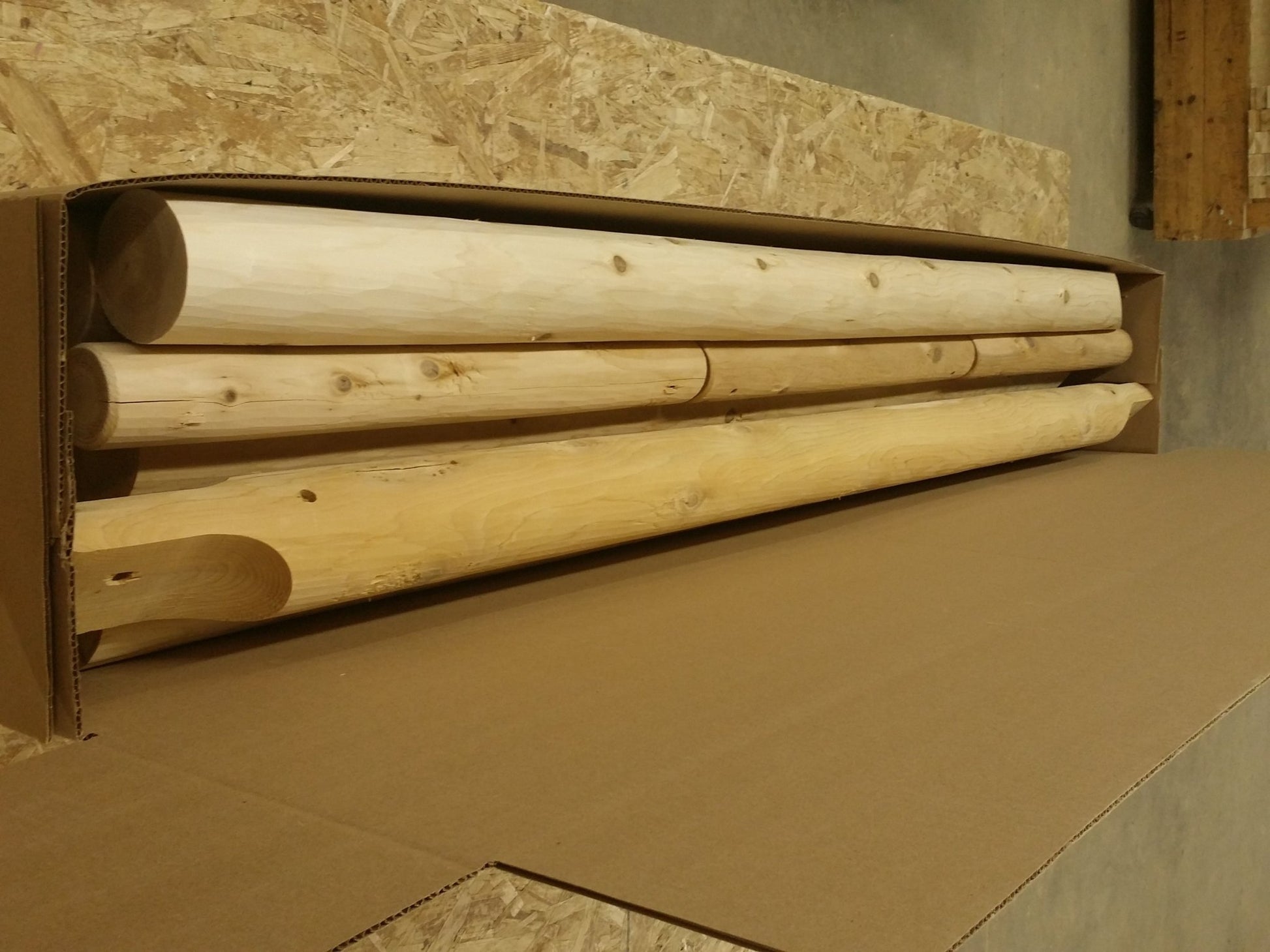 Pre-cut wooden logs packaged for easy assembly of a log swing set