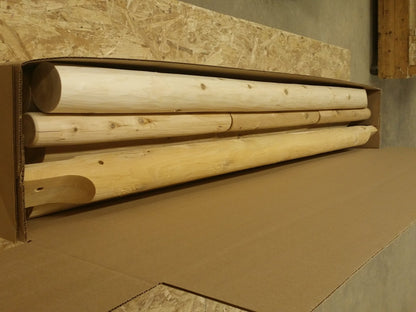 Pre-cut wooden logs packaged for easy assembly of a log swing set