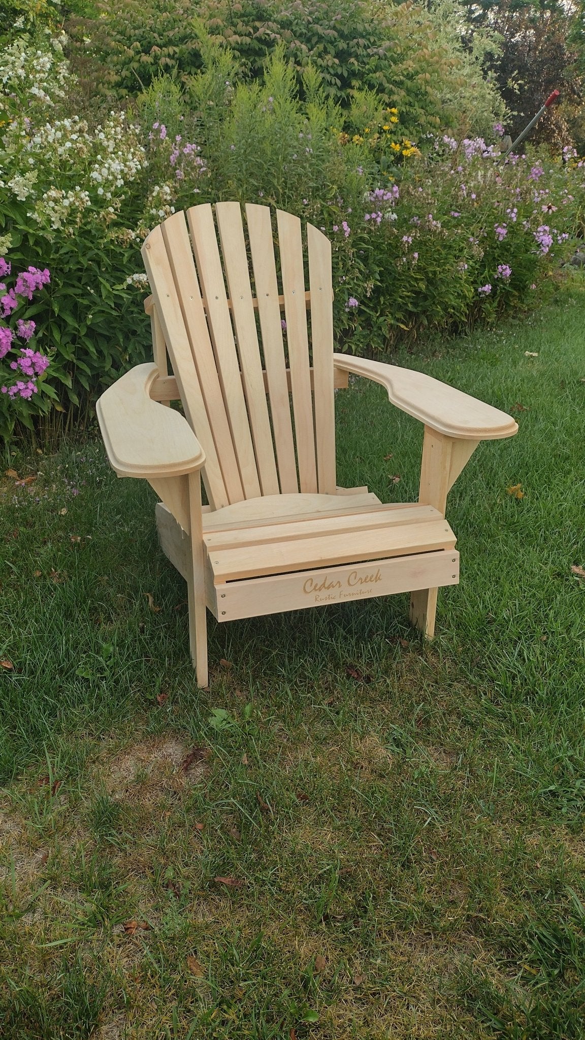 Front view of a patio chair adirondack style, featuring a slatted back and sturdy construction in a garden setting.