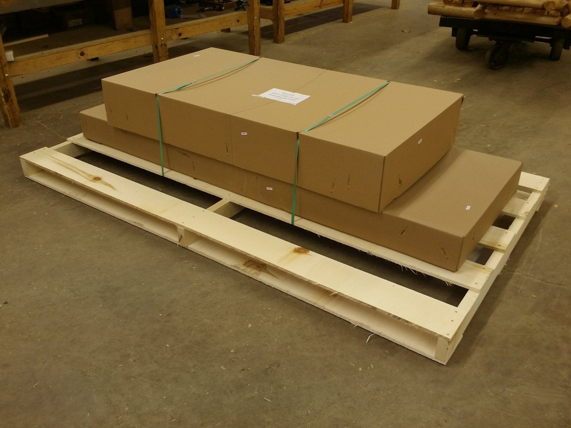 Boxes containing an outdoor farmhouse table and chairs set, securely packed on a wooden pallet for shipping.