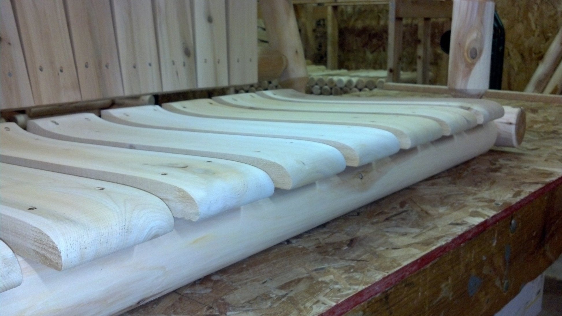 Contoured wooden slats ensuring ergonomic support in a handmade wooden rocking chair.