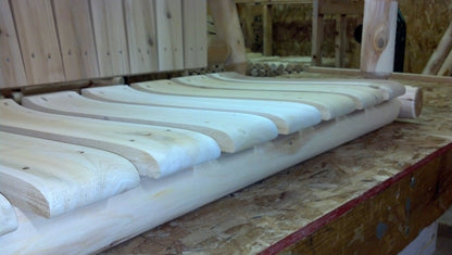 Contoured wooden slats ensuring ergonomic support in a handmade wooden rocking chair.